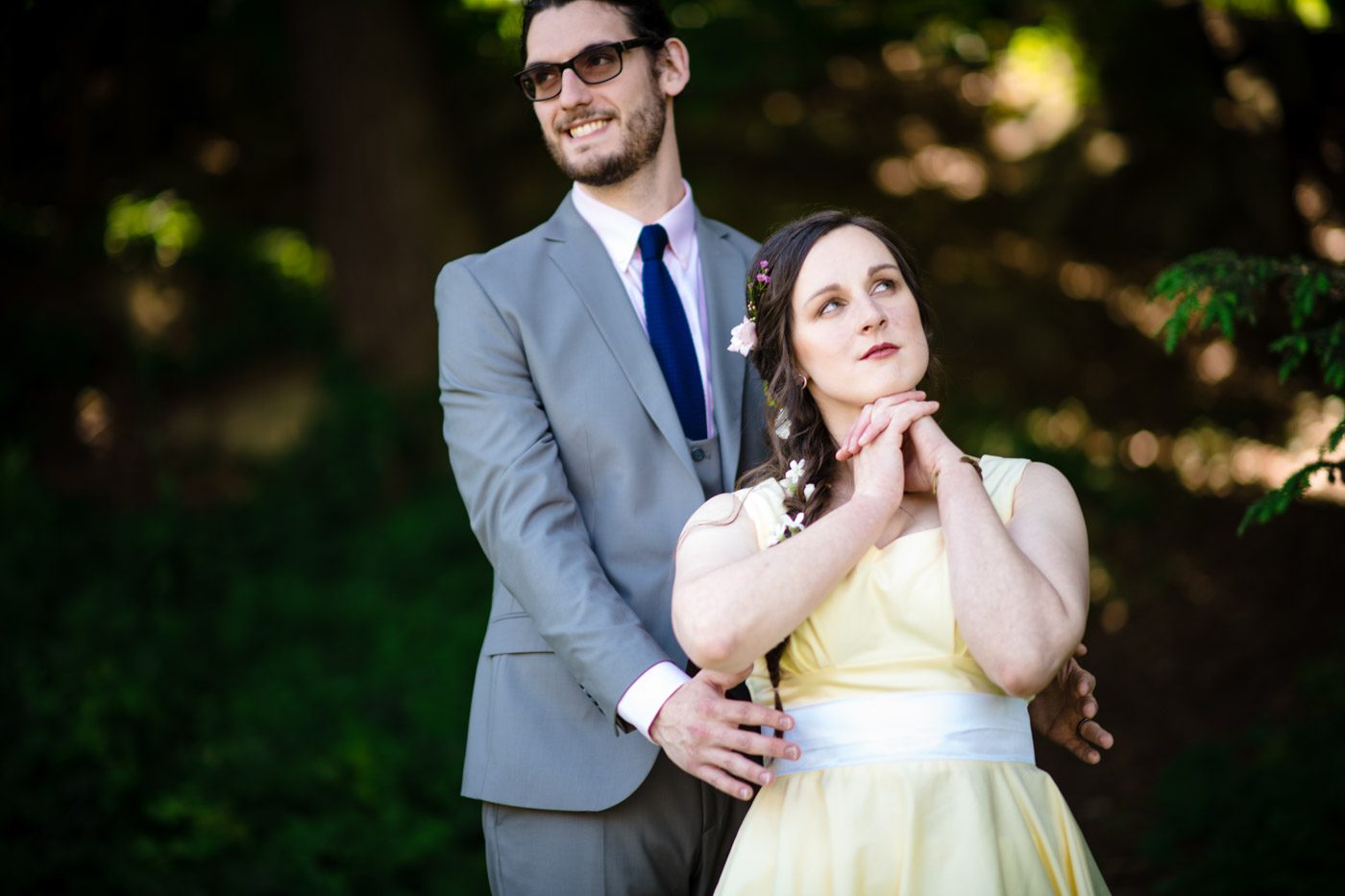 Wedding Photography groom-smiling-in-back-of-bride-who-is-daydreaming-in-the-garden